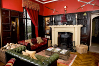 <p>Here’s one of the home’s living room that features gothic decor and wood paneling. (Airbnb) </p>