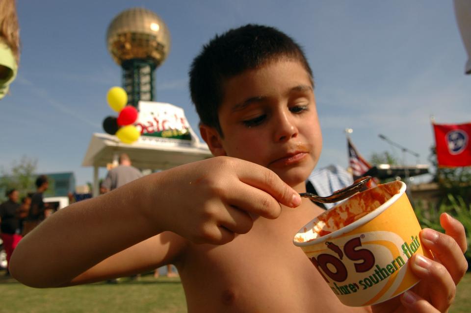 8-year-old Angel Augustine digs into the last few bites of his Petro at World's Fair Park in 2001. Petro's, which premiered at the 1982 World's Fair, were being handed out during Knoxville Mayor Bill Haslam's announcement of plans for the 25th anniversary of the 1982 World's Fair celebration.