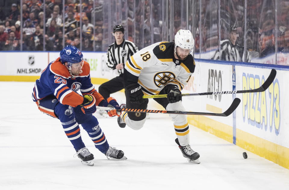 Boston Bruins' Pavel Zacha (18) and Edmonton Oilers' Leon Draisaitl (29) battle for the puck during first-period NHL hockey game action in Edmonton, Alberta, Monday, Feb. 27, 2023. (Jason Franson/The Canadian Press via AP)