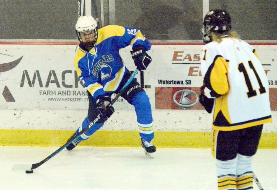 Michael Weisenburger of the Aberdeen Cougars connects with the puck as Watertown's Jake Bramer looks on during their SDAHA varsity boys hockey game on Tuesday, Dec. 20, 2022 in Watertown's Maas Ice Arena. Aberdeen pulled away for a 6-3 win.