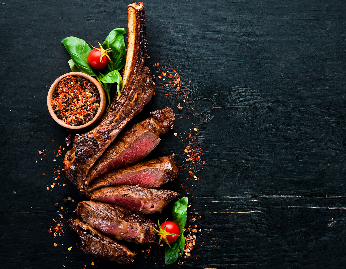 tomahawk steak On a black wooden background