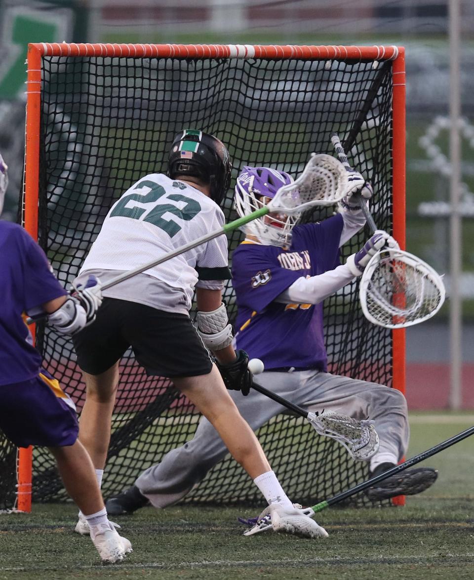 Yorktown's Jack Baker (22) fires a shot that was stopped by John Jay goalie Andrew Minard (18) during boys lacrosse action at Yorktown High School April 26, 2022. Yorktown won the game 10-4.