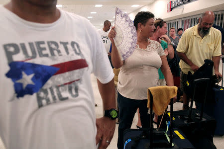 Stranded tourists and Puerto Ricans line up at the International Airport as they try to leave after Hurricane Maria devastated power and communications across the island, in San Juan, Puerto Rico September 25, 2017. REUTERS/Alvin Baez