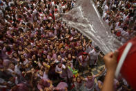 <p>A neighbor throws a bucket of water from a balcony to cool down revelers afterthe launch of the <em>chupinazo</em> rocket to celebrate the official opening of the 2017 San Fermín Fiesta. (Photo: Alvaro Barrientos/AP) </p>