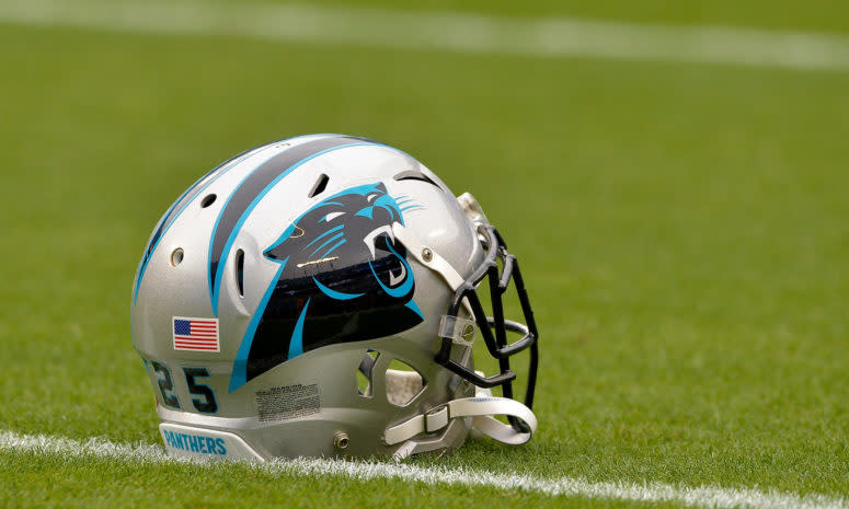 A Carolina Panthers helmet sitting on the field.