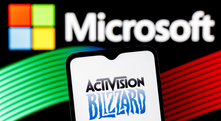 The logo for Activision Blizzard (ATVI) is shown on a phone screen in front of the Microsoft logo.