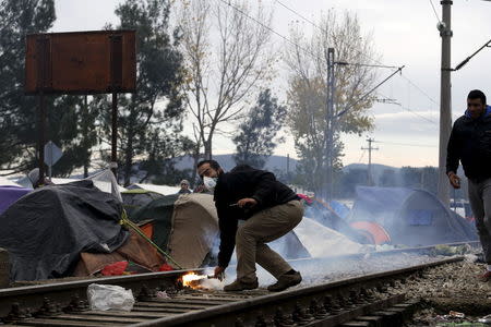 A stranded migrant prepares to throw a tear gas canister back to Macedonian police officers, as minor clashes broke out during a protest against the building of a metal fence at the Greek-Macedonian borders near the village of Idomeni, Greece November 28, 2015. REUTERS/Yannis Behrakis