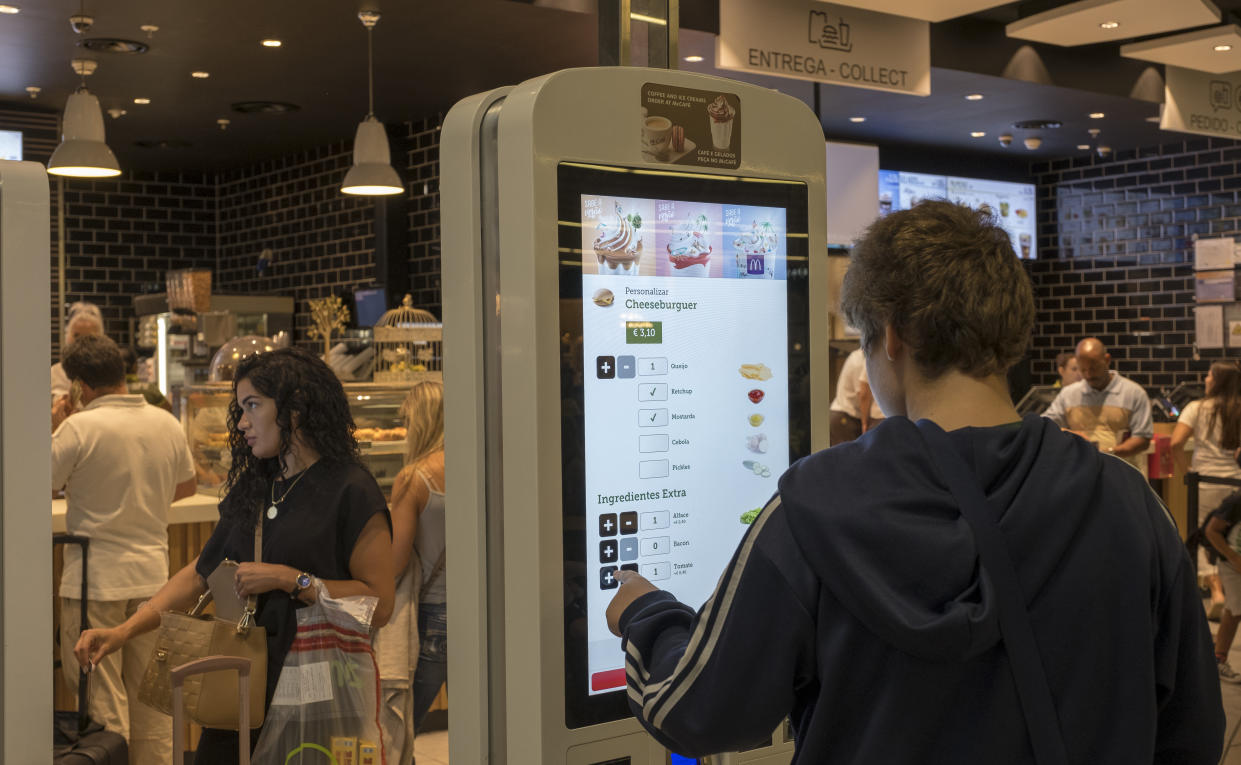 A man orders a meal using McDonald's restaurant digital menu boards self-serve kiosks with touch screen in passenger area at Terminal 1 of Humberto Delgado International Airport on September 04, 2018 in Lisbon, Portugal. Portuguese tourist industry has gone through an excellent year in 2018, for the country is rated as very safe by travelers. (Photo by Horacio Villalobos - Corbis/Corbis via Getty Images)