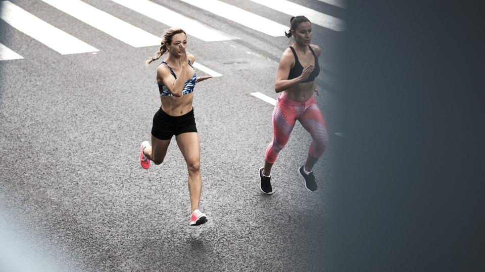 Two young women running on the street