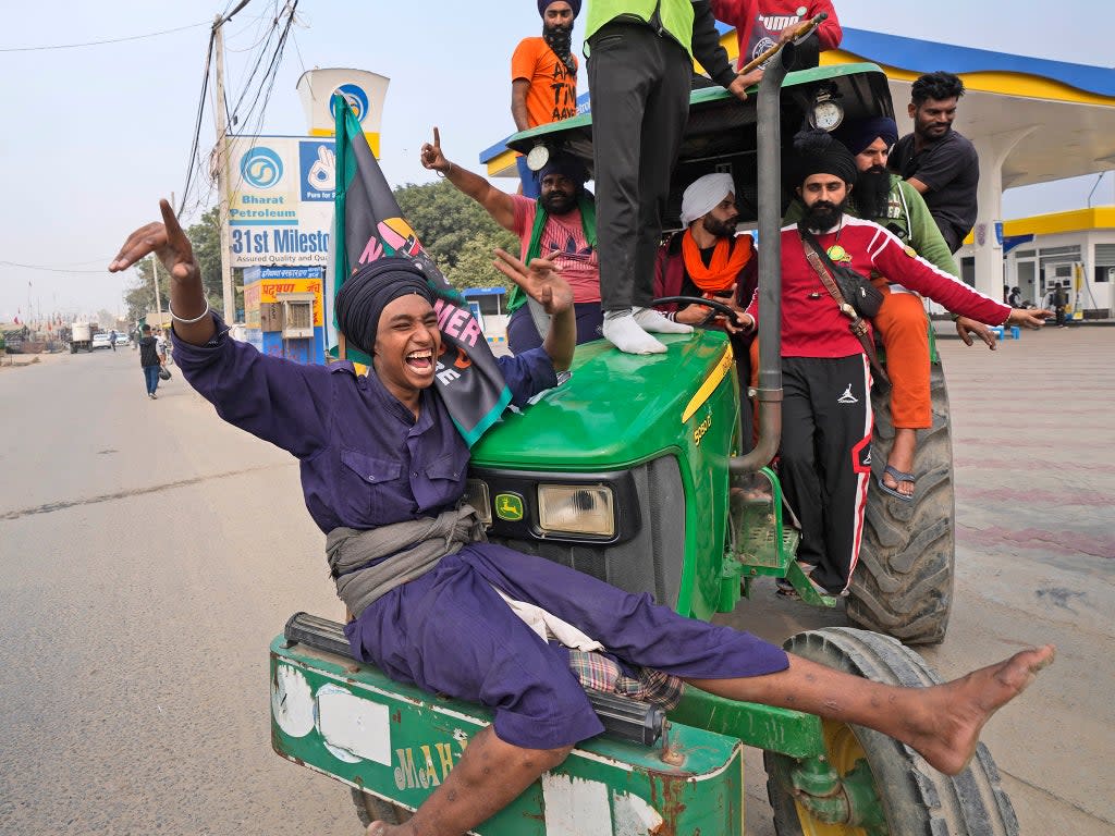 Farmers celebrate the repeal in Singhu, on the outskirts of Delhi (AP)