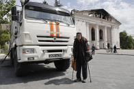 A man walks next to a theater building that has been bombed, in Mariupol, in territory under the government of the Donetsk People's Republic, eastern Ukraine, Saturday, May 21, 2022. (AP Photo/Alexei Alexandrov)