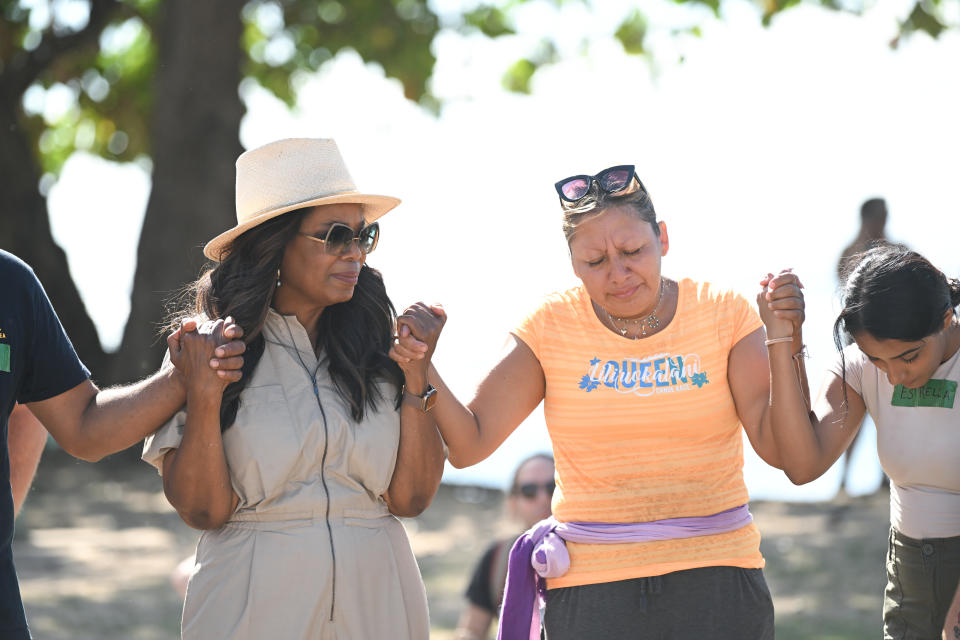 oprah holding hands with locals