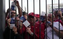 Liverpool fans show tickets and wait in front of the Stade de France prior the Champions League final soccer match between Liverpool and Real Madrid, in Saint Denis near Paris, Saturday, May 28, 2022. Police have deployed tear gas on supporters waiting in long lines to get into the Stade de France for the Champions League final between Liverpool and Real Madrid that was delayed by 37 minutes while security struggled to cope with the vast crowd and fans climbing over fences. (AP Photo/Christophe Ena)