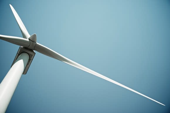 A wind turbine against a blue sky.