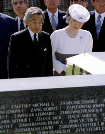 FILE PHOTO : Japanese Emperor Akihito, flanked by Empress Michiko, looks at names of American soldiers who died in the Okinawa battles during World War Two on one of the stone monuments as he visits Okinawa Peace Memorial Park August 2, 1995. REUTERS/Susumu Toshiyuki/File Photo