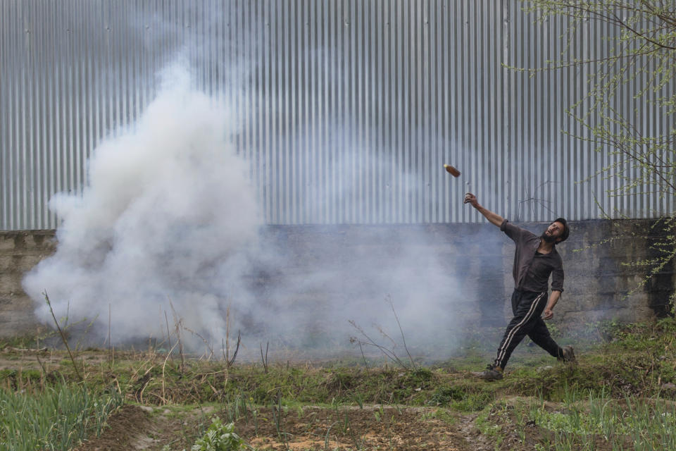 A Kashmiri protester throws a glass bottle at Indian security forces during a protest near the site of a gun battle in Chadoora town, about 25 kilometers (15 miles) south of Srinagar, Indian controlled Kashmir, Tuesday, March 28, 2017. Three civilians were killed and 28 other people were injured in anti-India protests that erupted Tuesday following a gunbattle between rebels and government forces that killed a rebel in disputed Kashmir, police and witnesses said. The gunbattle began after police and soldiers cordoned off the southern town of Chadoora following a tip that at least one militant was hiding in a house, said Inspector-General Syed Javaid Mujtaba Gillani. As the fighting raged, hundreds of residents chanting anti-India slogans marched near the area in an attempt to help the trapped rebel escape.(AP Photo/Dar Yasin)