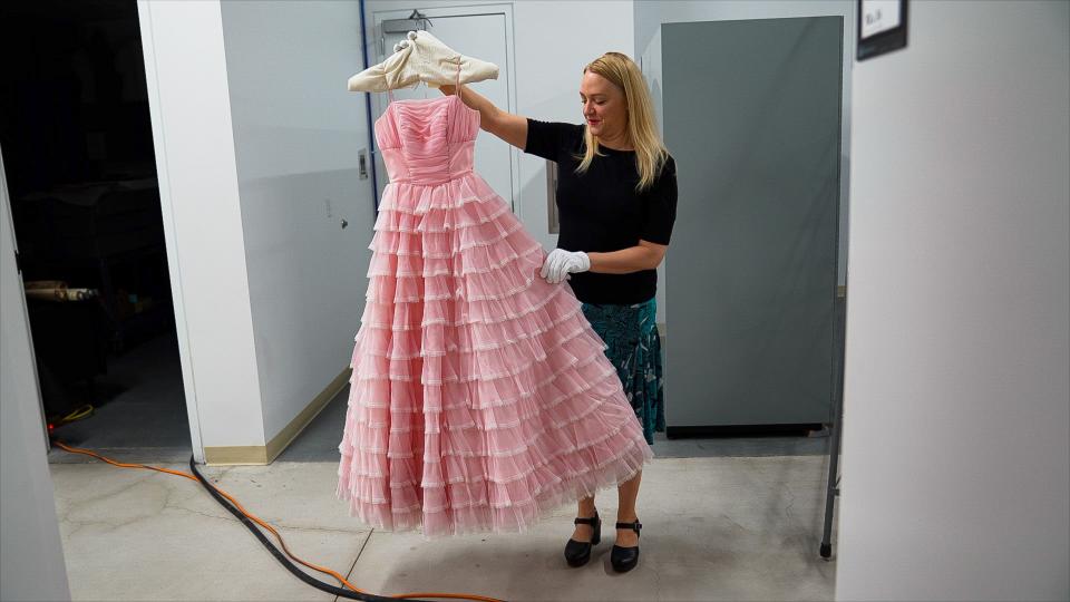 Lesley Struc displays a 1960s-era pink prom dress worn by Karen Brunz.