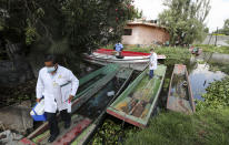 Dr. Jorge Ballesteros gets off a boat on his way to collect samples to test for COVID-19 at a home, in Xochimilco, Mexico City, Wednesday, August 5, 2020. (AP Photo/Eduardo Verdugo)