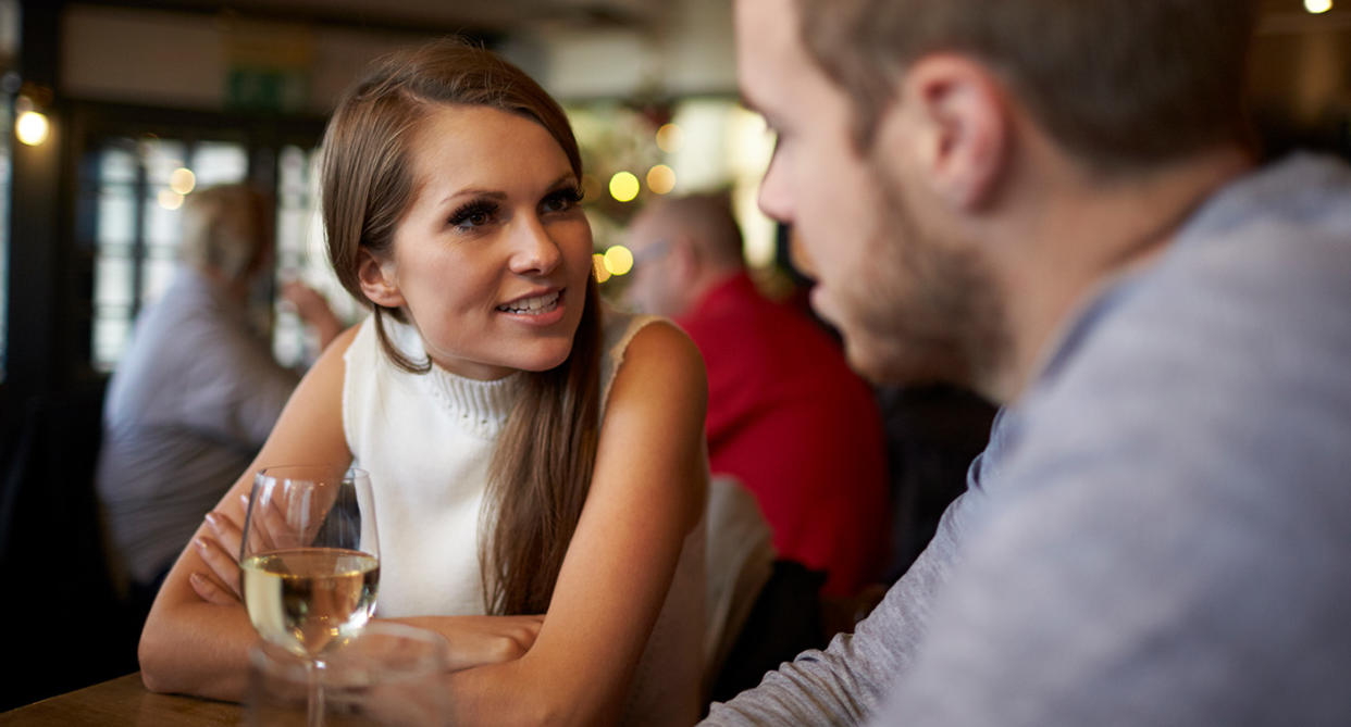 Man and woman talking on a date. (Getty Images)