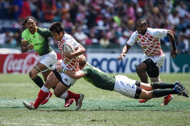 Japan's Katsuyuki Sakai (L) is tackled by South Africa's Philip Snyman during a match at the rugby sevens tournament in Hong Kong on March 28, 2015