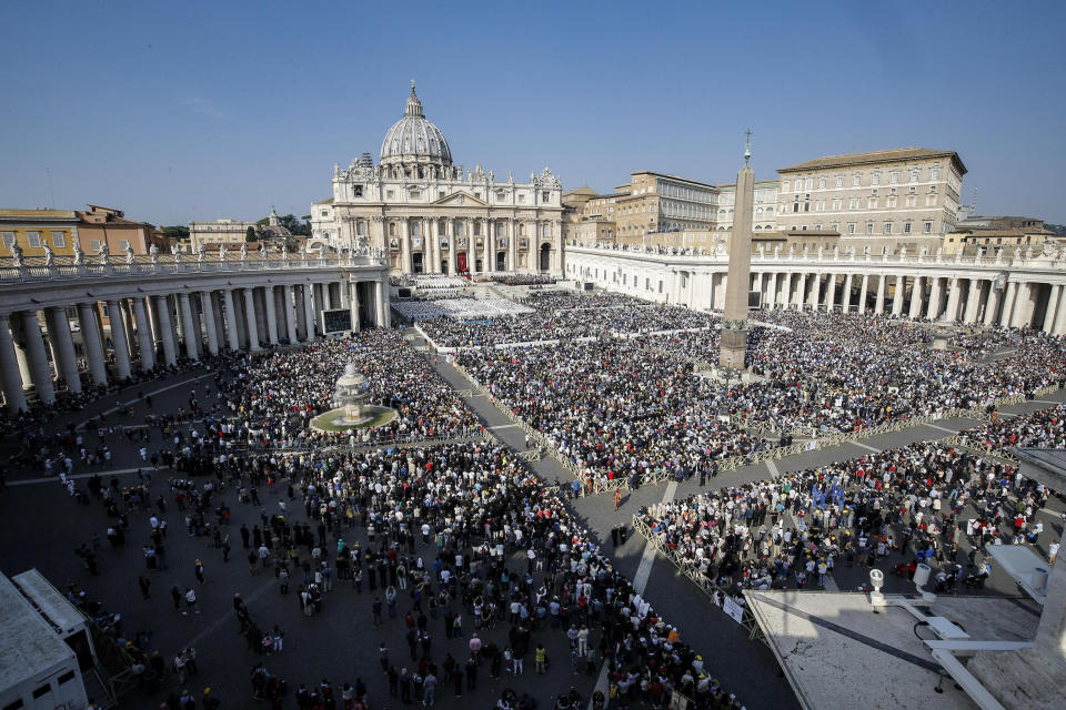 Faithful gather prior to a canonization ceremony in St. Peter's Square at the Vatican, Sunday, Oct. 14, 2018. Pope Francis has declared Pope Paul VI and slain Salvadoran Archbishop Oscar Romero saints, reciting in Latin the rite of canonization at the start of Mass in St. Peter's Square. After hearing brief biographies of Paul, Romero and five other people canonized Sunday, Francis declared them saints and "decreed that they are to be venerated as such by the whole church." (Giuseppe Lami/ANSA via AP)