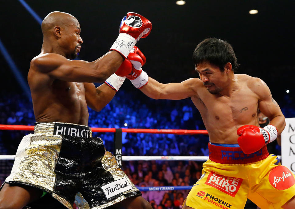 LAS VEGAS, NV - MAY 02:  Manny Pacquiao throws a right at Floyd Mayweather Jr. during their welterweight unification championship bout on May 2, 2015 at MGM Grand Garden Arena in Las Vegas, Nevada.  (Photo by Al Bello/Getty Images)