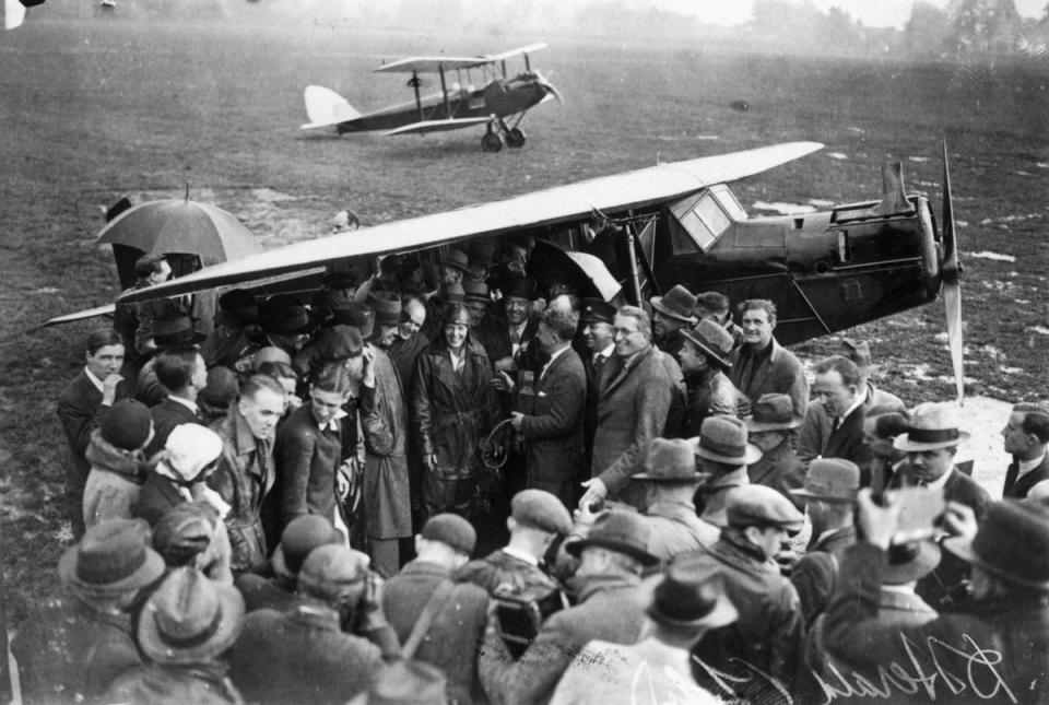 La aviadora estadounidense Amelia Earhart (1898-1937), en el centro, rodeada de una multitud de simpatizantes y periodistas a su llegada al aeródromo de Hanworth tras cruzar el Atlántico. (Getty)