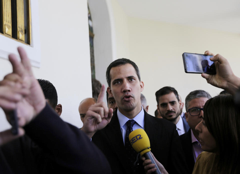 Opposition National Assembly President Juan Guaido, who has declared himself interim president of Venezuela, speaks with the media upon his arrival to National Assembly, in Caracas, Venezuela, Tuesday, Jan. 29, 2019. Venezuela's chief prosecutor on Tuesday asked the country's top court to ban opposition leader Guaido from leaving the country, launching a criminal probe into his anti-government activities while international pressure builds against President Nicolas Maduro.(AP Photo/Fernando Llano)