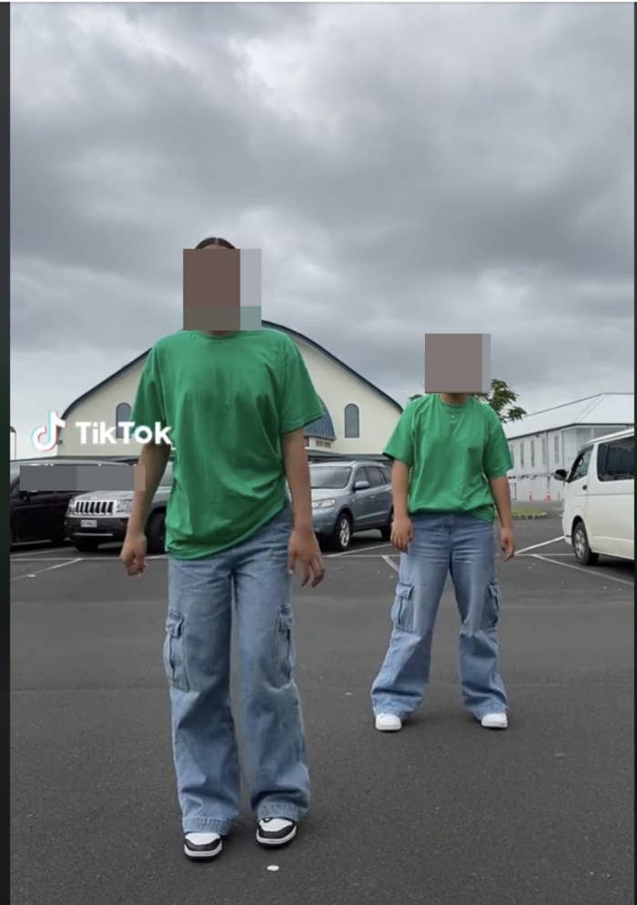 two people in matching outfits dancing outside in a parking lot