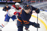 Edmonton Oilers' Kailer Yamamoto (56) is checked by Montreal Canadiens' Phillip Danault (24) during the second period of an NHL hockey game Wednesday, April 21, 2021, in Edmonton, Alberta. (Jason Franson/The Canadian Press via AP)