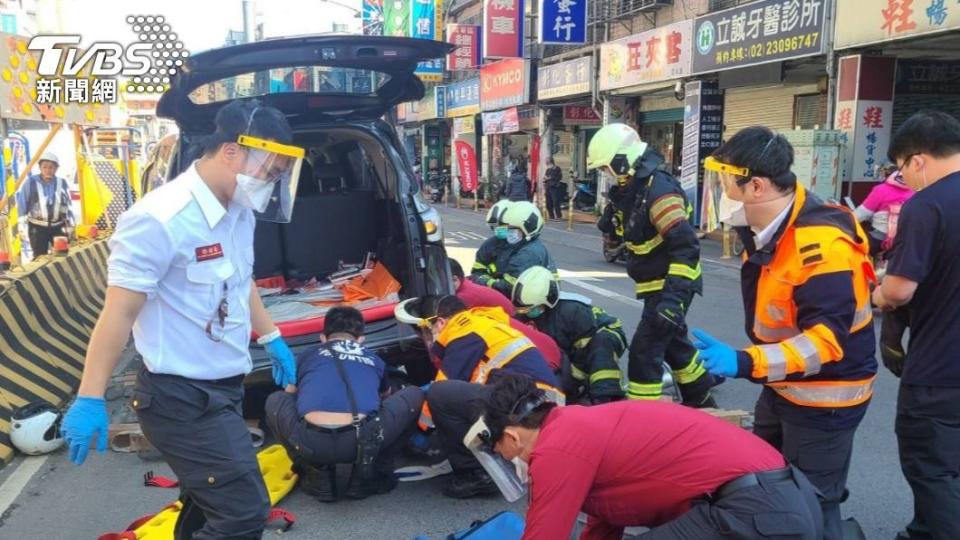 消防人員將車輛架高，救出底下的騎士。（圖／TVBS）