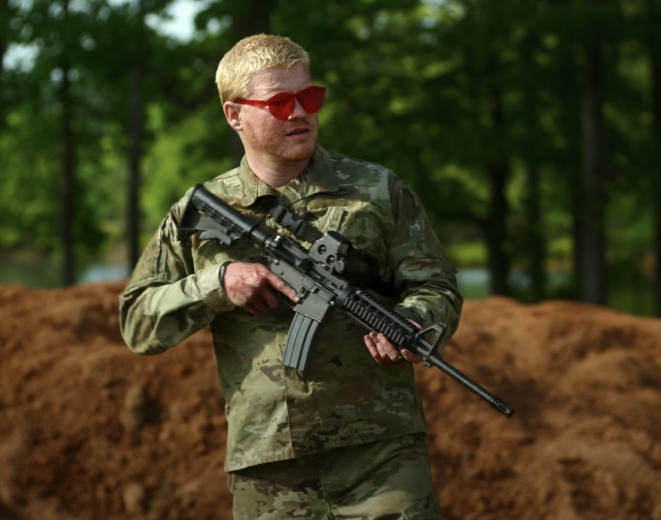 a man in camouflage holding a gun