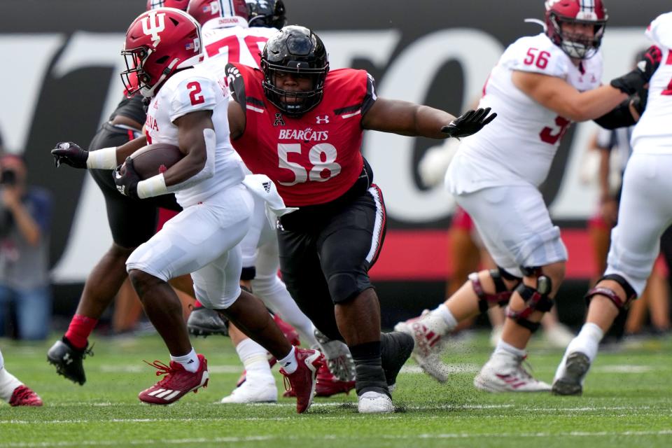 Cincinnati Bearcats defensive lineman Dontay Corleone (58) tackles Indiana Hoosiers running back Shaun Shivers (2) in the first quarter of a college football game, Saturday, Sept. 24, 2022, at Nippert Stadium in Cincinnati. 