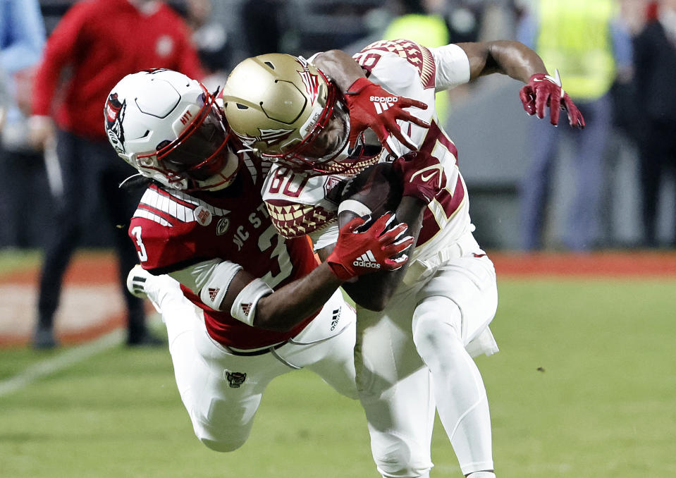 Florida State's Ontaria Wilson (80) catches a pass front of North Carolina State's Aydan White (3) during the first half of an NCAA college football game in Raleigh, N.C., Saturday, Oct. 8, 2022. (AP Photo/Karl B DeBlaker)