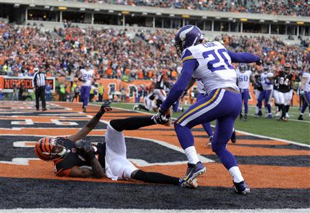 Dec 22, 2013; Cincinnati, OH, USA; Cincinnati Bengals wide receiver A.J. Green (18) lays on the ground after catching a long pass for a touchdown while being covered by Minnesota Vikings cornerback Chris Cook (20) during the second half of the game at Paul Brown Stadium. Cincinnati Bengals beat Minnesota Vikings 42-14. Mandatory Credit: Marc Lebryk-USA TODAY Sports