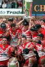 Bobbie Goulding, holding the trophy, celebrates with his St Helens team-mates