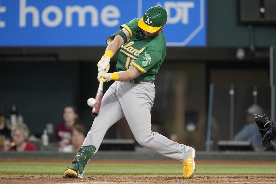 Oakland Athletics' Seth Brown connects for a run-scoring single in the third inning of a baseball game against the Texas Rangers, Sunday, Sept. 10, 2023, in Arlington, Texas. Zack Gelof scored on the hit. (AP Photo/Tony Gutierrez)