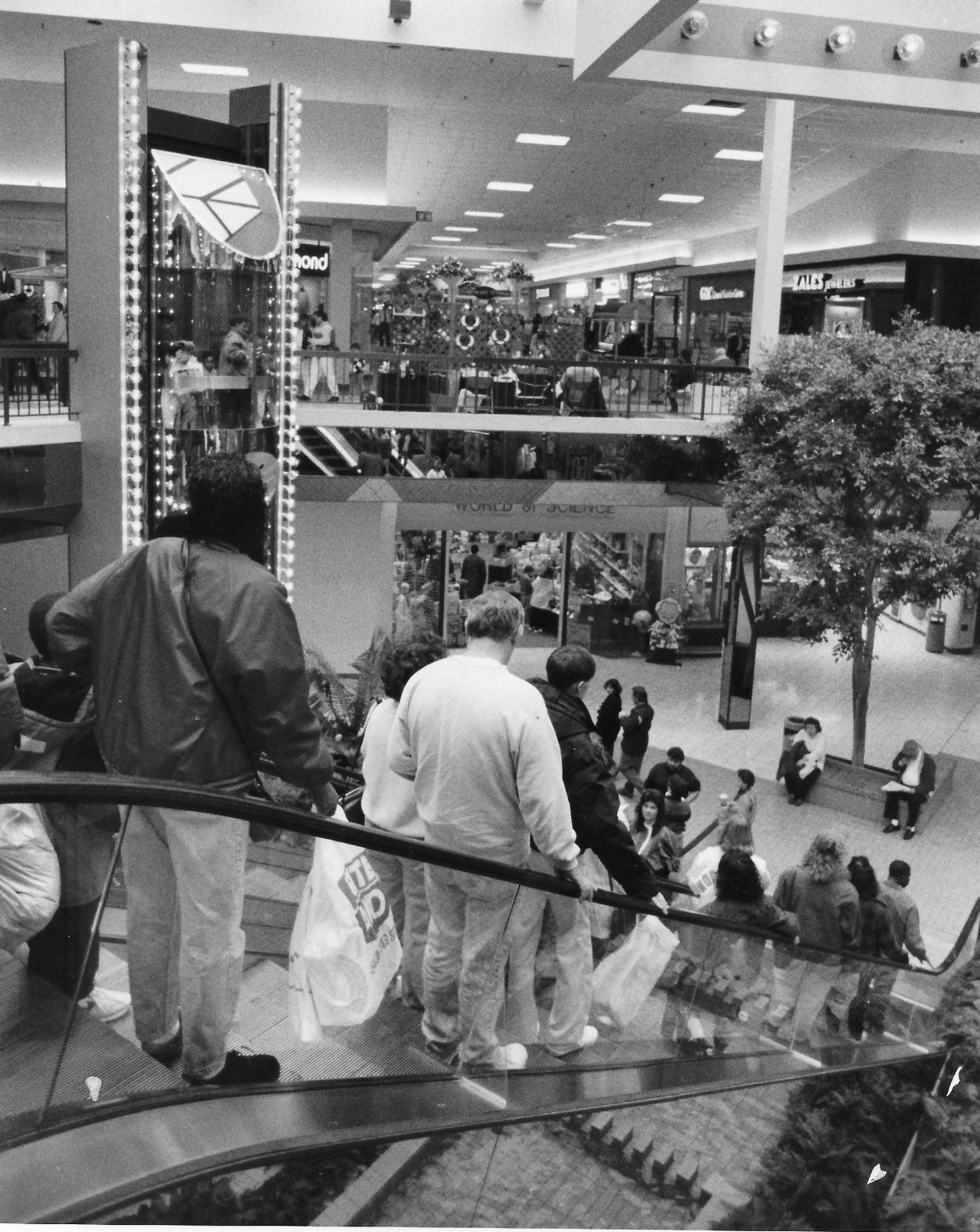 Akron shoppers use the escalators at Rolling Acres Mall in 1992. The bubble elevator is visible in the background.