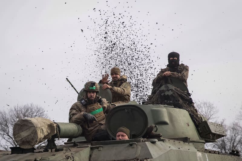 FILE PHOTO: Ukrainian service members ride a self-propelled howitzer near Bakhmut