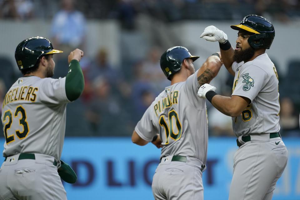 Oakland Athletics' Shea Langeliers (23), Chad Pinder (10) and Dermis Garcia, right, celebrate a three-run home run by Garcia during the first inning of the team's baseball game against the Texas Rangers in Arlington, Texas, Tuesday, Sept. 13, 2022. (AP Photo/Tony Gutierrez)