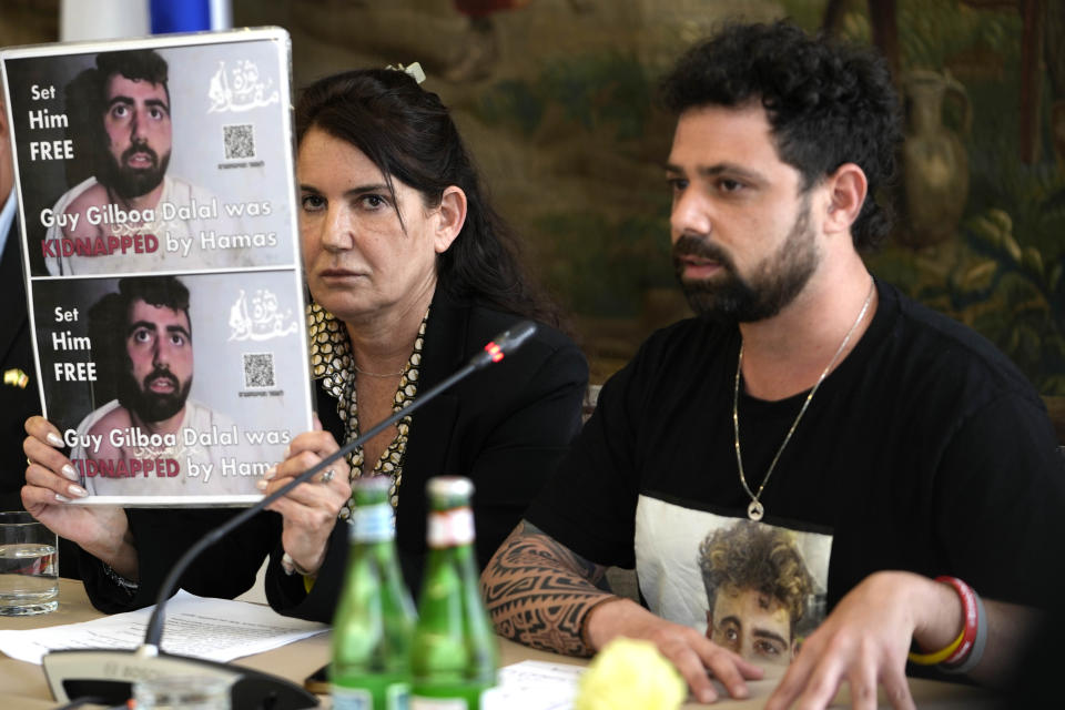 Meirav Gilboa-Dalal, left, shows a photo of her son Guy, one of the hostages being held by Hamas, as she's flanked by Guy's brother Gal, during a press conference in Rome, Monday, April 8, 2024. Pope Francis met Monday with relatives of hostages taken by Hamas on Oct. 7, marking the six-month anniversary of the attack in southern Israel with an hourlong audience. (AP Photo/Alessandra Tarantino)