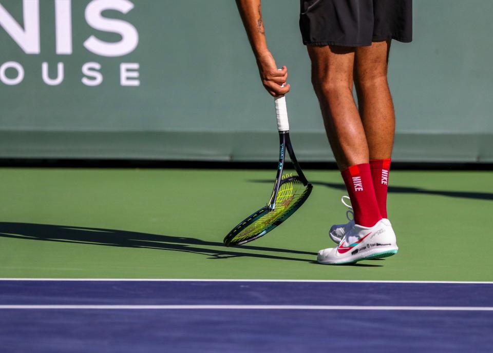 Nick Kyrgios of Australia picks up a broken racket after throwing it onto the court in frustration while playing his first set against Rafael Nadal of Spain during the quarterfinals at the BNP Paribas Open at the Indian Wells Tennis Garden in Indian Wells, California on Thursday .  , March 17, 2022.