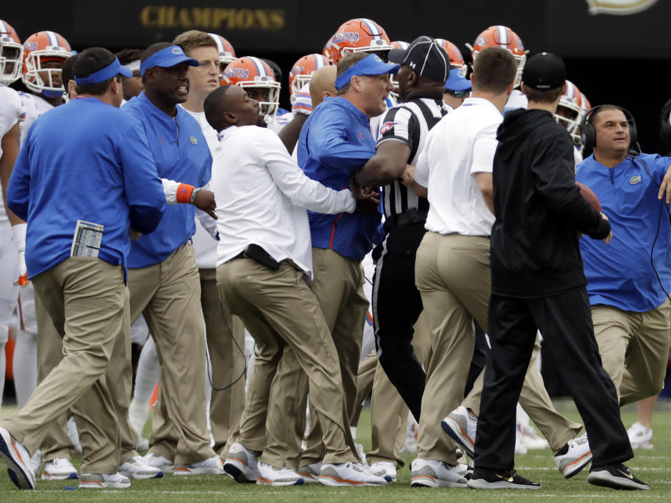 Florida head coach Dan Mullen, center, is restrained during a verbal confrontation with Vanderbilt coaches and players in the first half of an NCAA college football game Saturday, Oct. 13, 2018, in Nashville, Tenn. (AP Photo/Mark Humphrey)