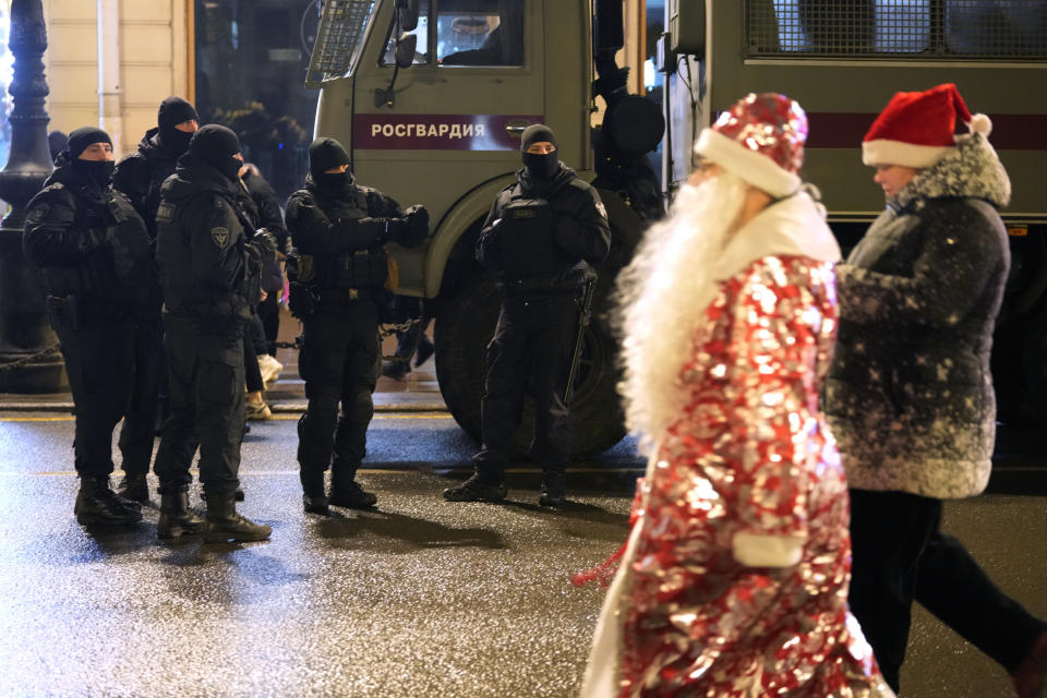 Riot police officers patrol an avenue during New Year's celebrations in downtown St. Petersburg, Russia, early Sunday, Jan. 1, 2023. (AP Photo/Dmitri Lovetsky)