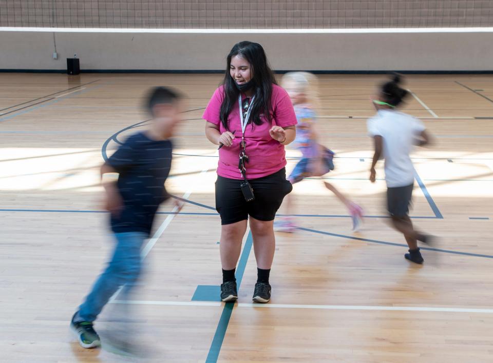 Children run past counselor Jesna Gayagoy during the YMCA afterschool program at the Vickrey Community Center in Pensacola on Tuesday.