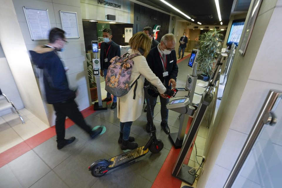 Employees have their certification checked as Italy's new “Green Pass” vaccination requirement for employees to enter their offices became mandatory, at the Trenitalia, Italian train company offices, in Rome, Friday, Oct. 15, 2021. From Friday, certification is required for public and private workplaces. Both employees and employers risk fines if they don’t comply. Public sector workers can be suspended if they show up five times without a Green Pass. The pass is already required in Italy to enter museums, theaters, gyms and indoor restaurants, as well as to take long-distance trains and buses or domestic flights. The passes show that a person has had least one COVID-19 vaccine dose, or recovered from the virus in the last six months, or has tested negative in the last 48 hours. (AP Photo/Andrew Medichini)