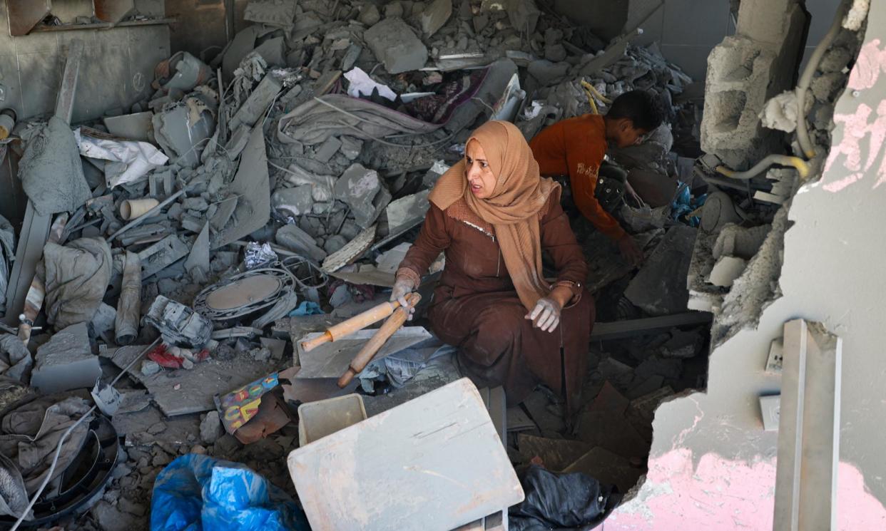 <span>A Palestinian woman salvages belongings from a house hit by overnight Israeli bombing in Rafah on Saturday.</span><span>Photograph: AFP/Getty Images</span>