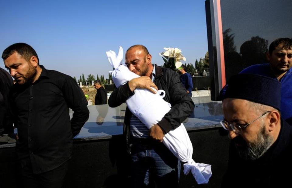 Un hombre lleva el cuerpo de su hija de 10 meses que falleció junto a otros familiares después de que un misil impactara en su casa de Ganja (Azerbaiyán) durante el conflicto en la región de Nagorno-Karabaj. Fotografía del 17 de febrero. (Foto: Umit Bektas / Reuters).
