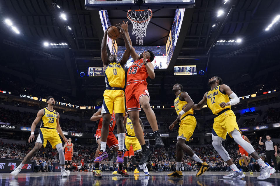 Indiana Pacers forward Reggie Perry (0) pulls down a rebound in front of Chicago Bulls center Tony Bradley (13) during the first half of an NBA basketball game in Indianapolis, Friday, Feb. 4, 2022. (AP Photo/AJ Mast)