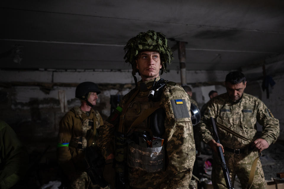 Militares del Batallón Sich de los Cárpatos del Ejército ucraniano se colocan su indumentaria en una base subterránea en la región de Járkov, en Ucrania, mientras esperan el cese del fuego de artillería en su posición, el miércoles 11 de mayo de 2022. (Lynsey Addario/The New York Times)
